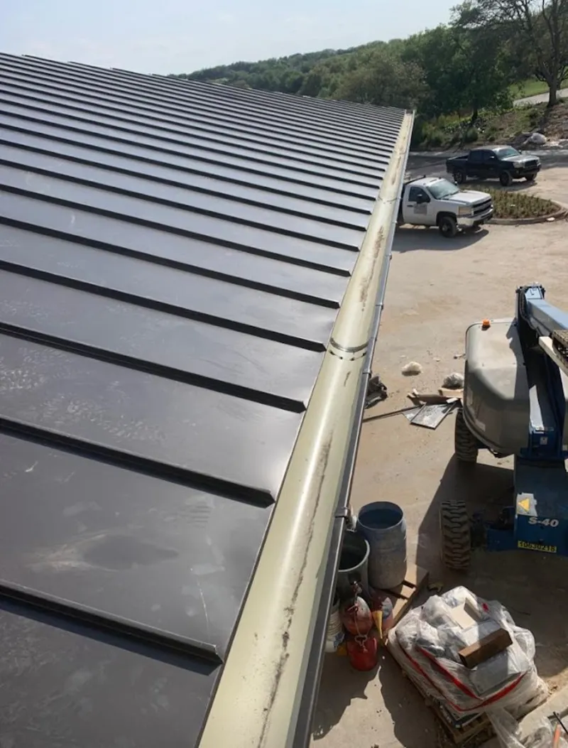 Standing seam panel and gutter detail on a metal roofing jobsite in Macclenny